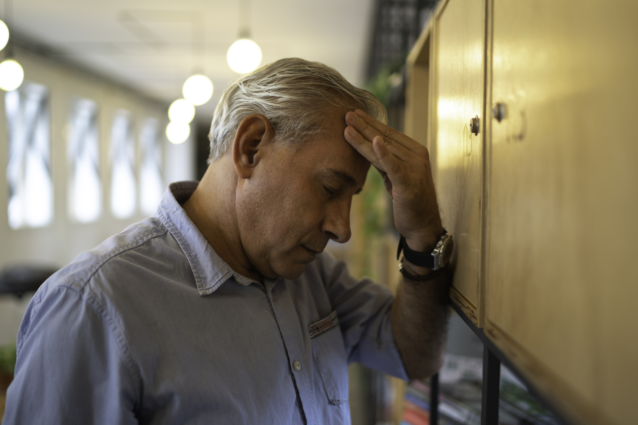 Older man frustrated rubbing his head